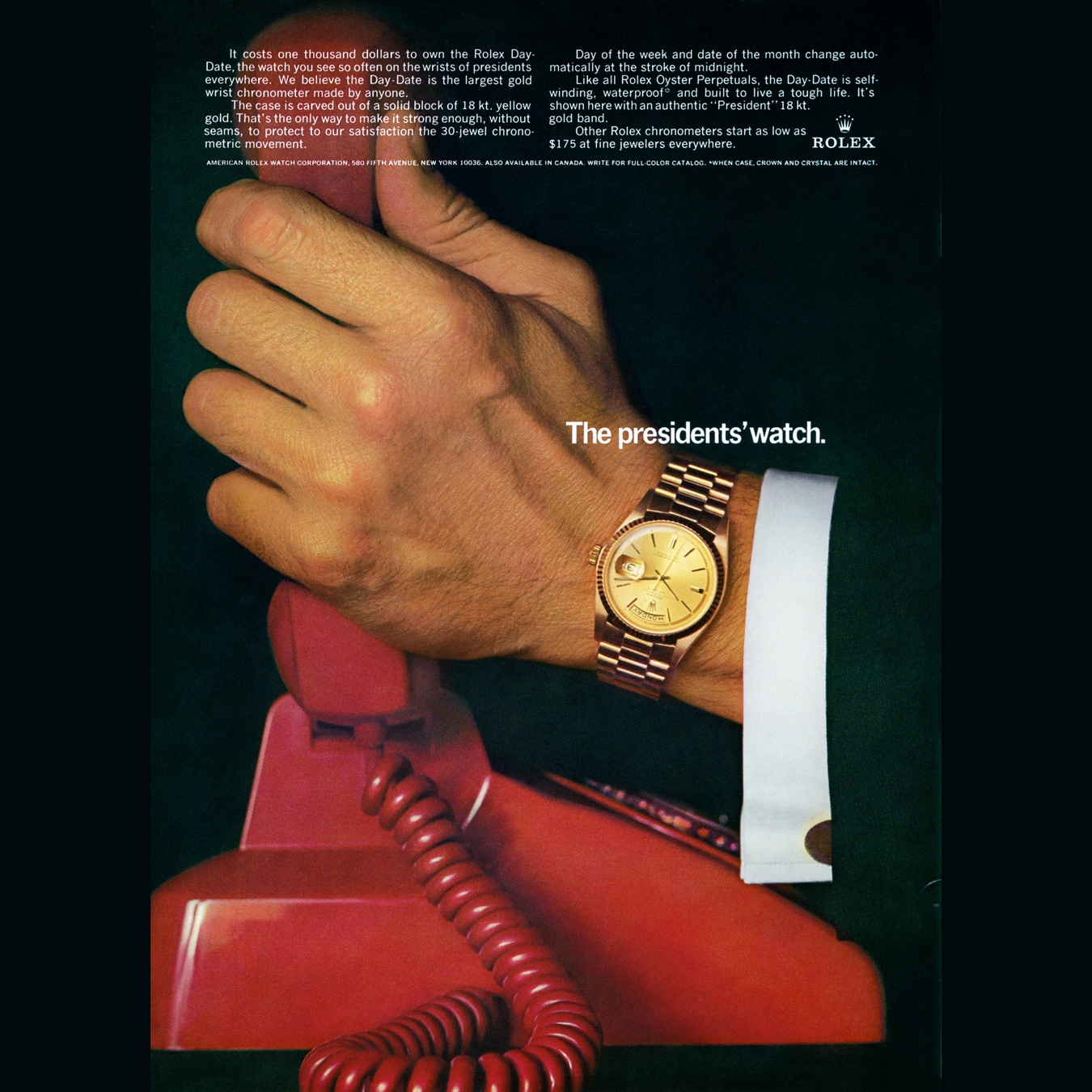 Rolex watch is worn in a hand while holding a red phone