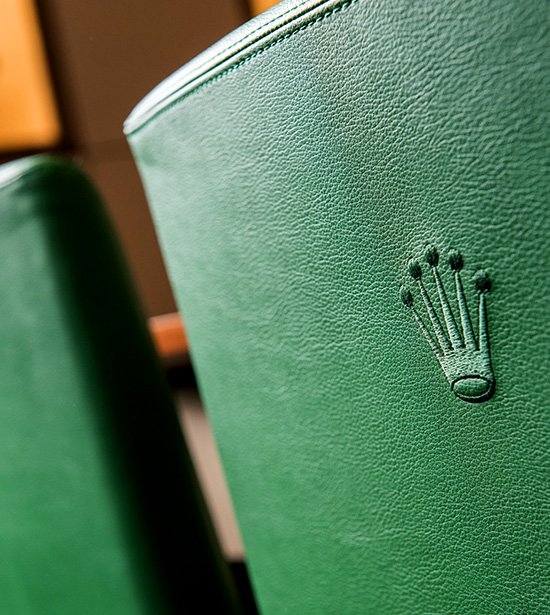 Rolex logo in a green leather chair